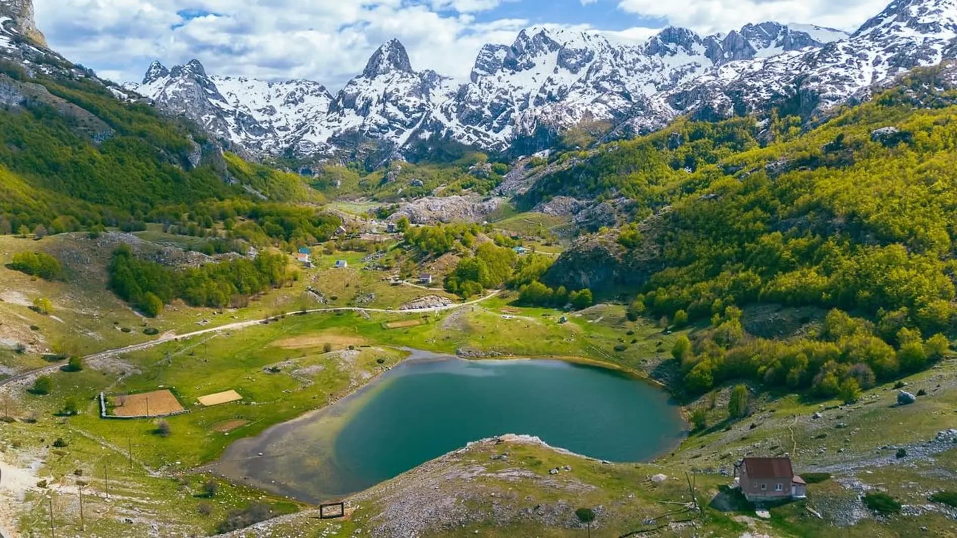 Drone view of Bukumirsko Lake beneath snowy peaks