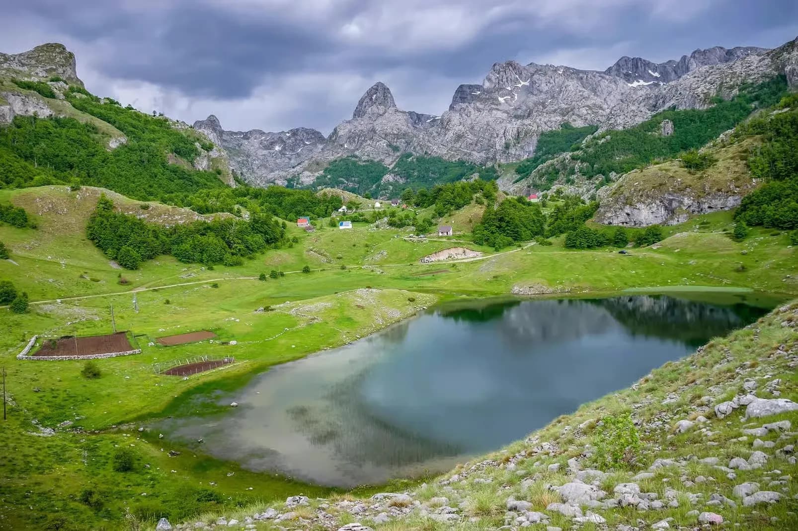 Bukumirsko Lake and green meadows under cloudy skies