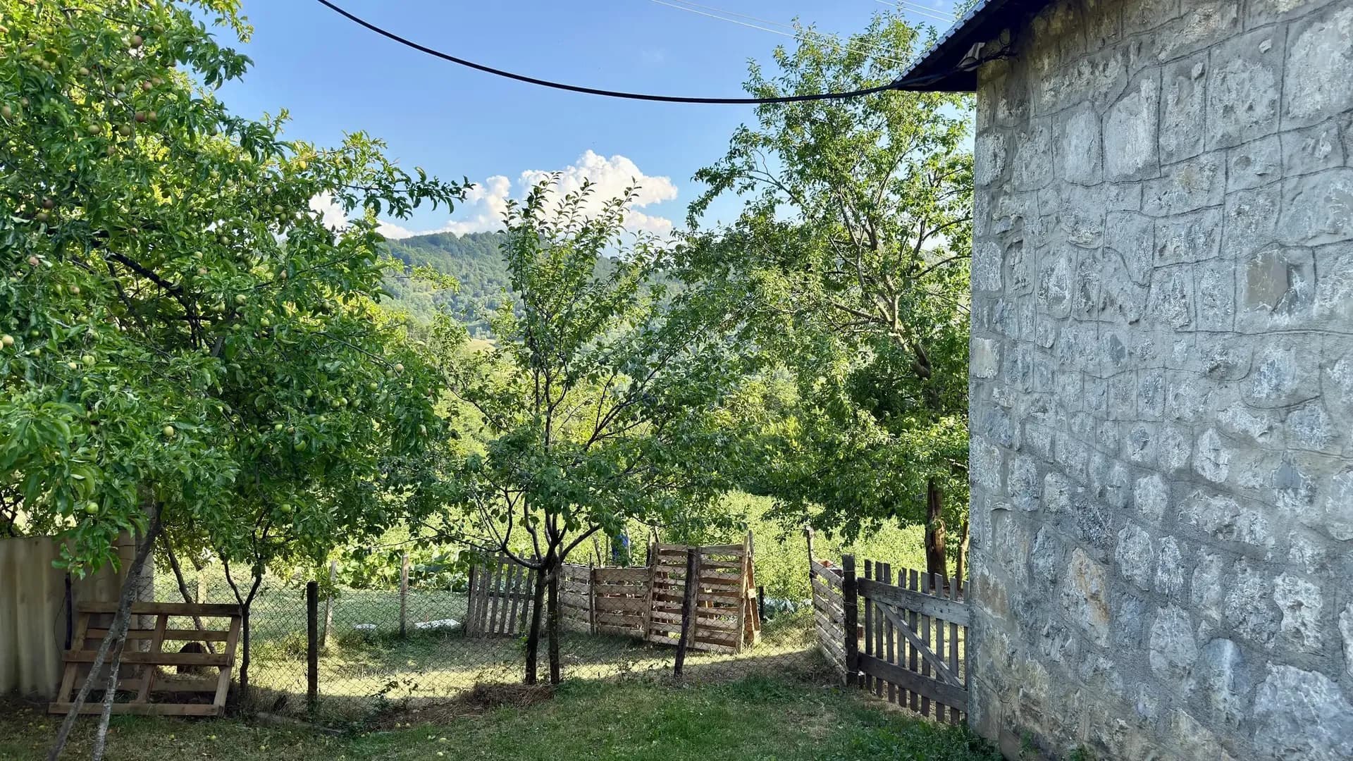 Stone house and orchard with mountain views